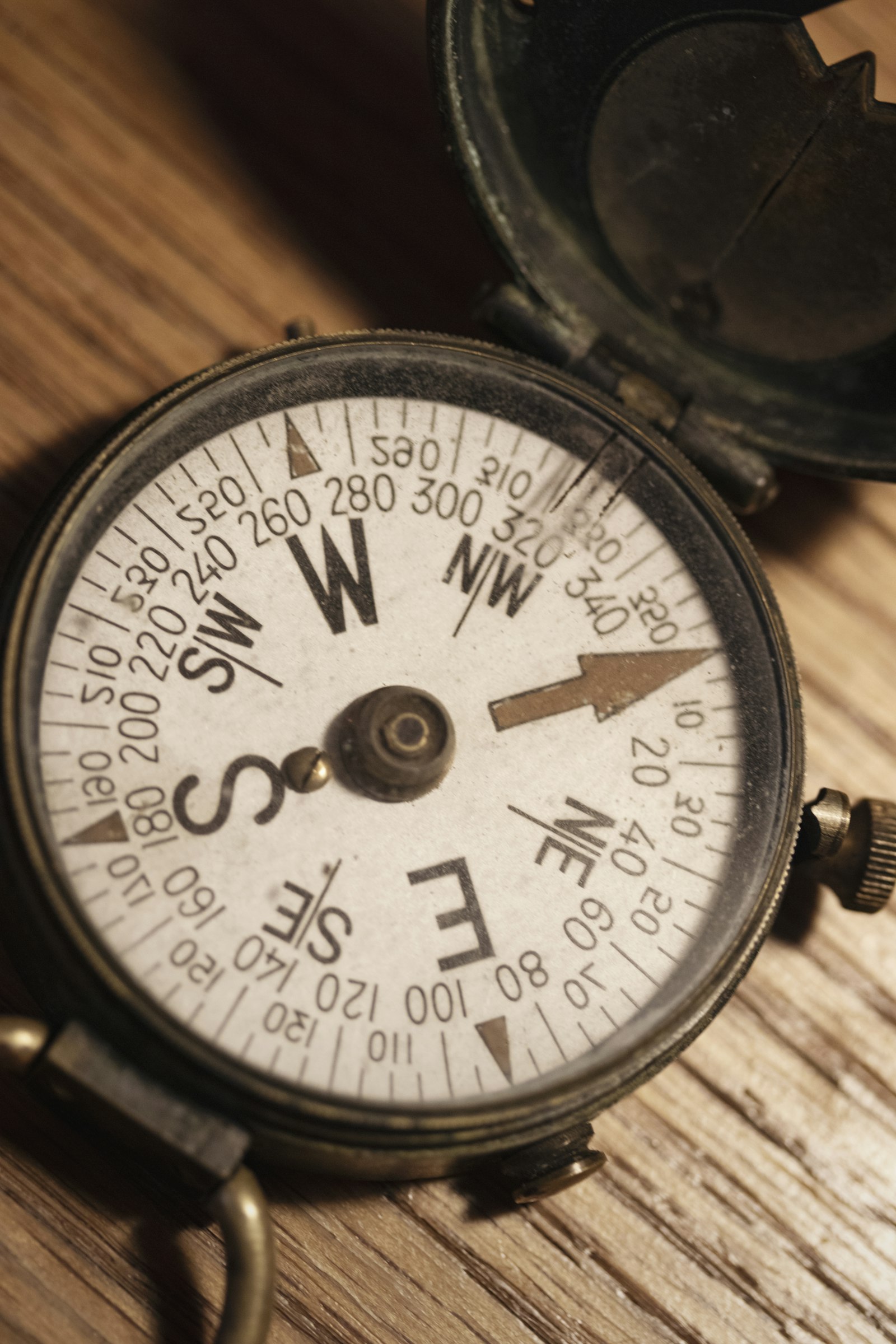 an old brass compass on a wooden table